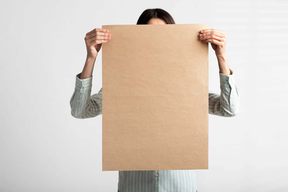 Qayta ishlangan qog'ozdan chizilgan tabelani ushlab turgan odam | Person holding signboard with drawing from recycled paper 1