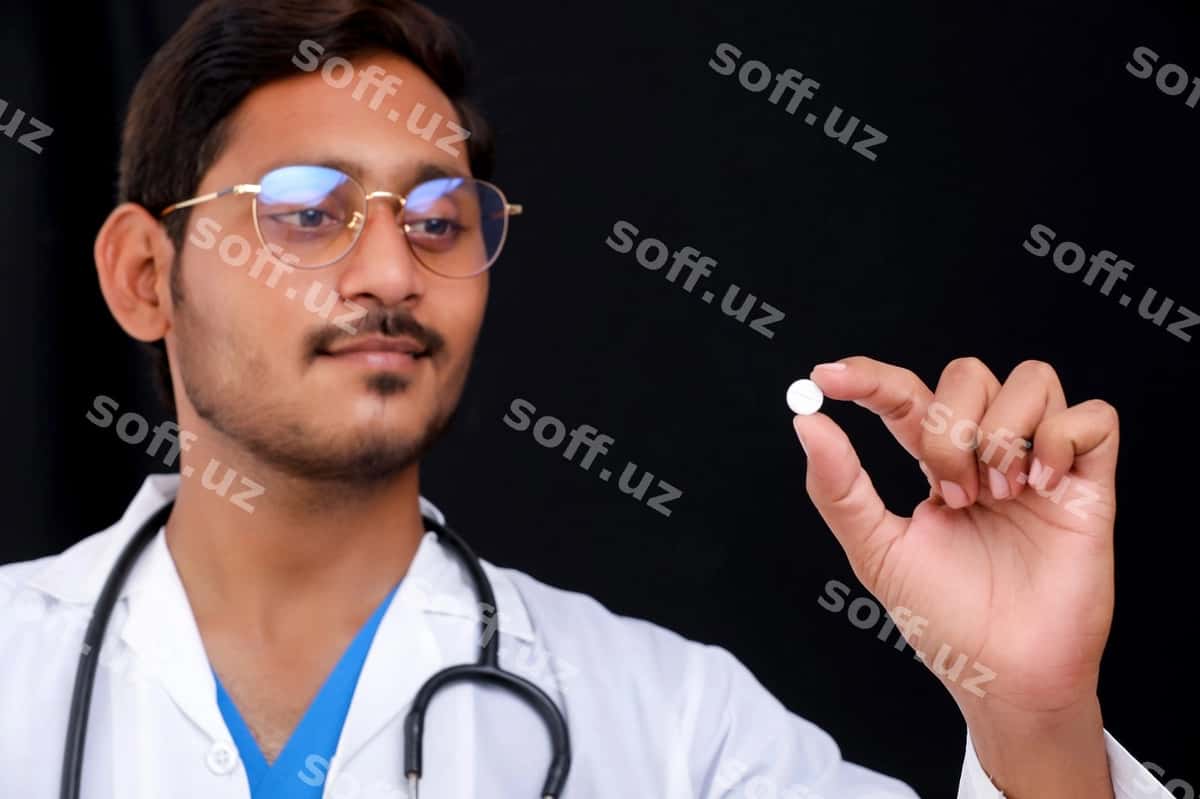 Yosh hindistonlik doktor qolqiqdagi tabletka ni tutgan | Young indian doctor holding pill hand 1