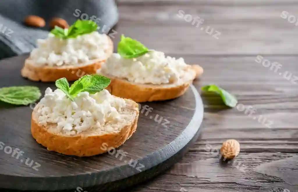 Nonni kesmalar sir bilan nane yaproqlari yog'ochli tovar yog'ochli orqa fon | Slices bread with cottage cheese mint leaves wooden cutting board wooden background