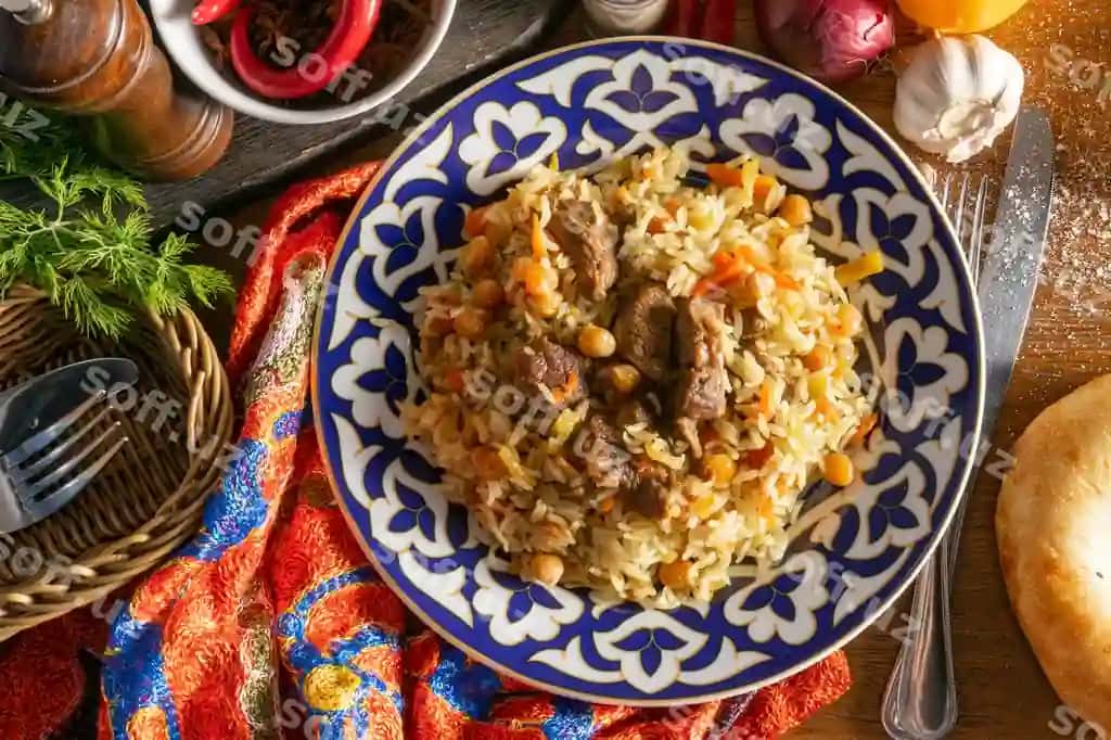 Qazi palov, an'iy sharqiy issiq taom, guruch, qazi, sariq morcha, sarimsoq, kishmish, nohat, zirvak, milliy o'zbek naqshi bilan disk. | Pilaf with lamb traditional oriental hot dish rice lamb yellow carrots with garlic raisins chickpeas turmeric plate with national uzbek ornament 2