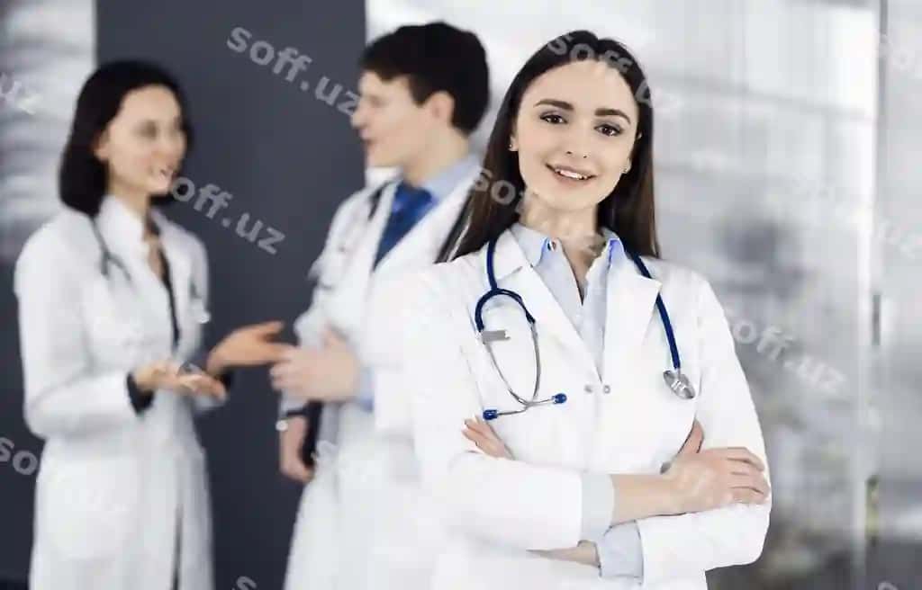 Gulchi aqlli ayol tabib ko'rsog'ini qo'shgan holda klinikada turibdi, hamda uning hamkasblari bilan, orqasida hamshiralar ishlaydigan portretlar, mukammal tibbiy xizmat, ospital mediklari. | Smiling intelligent woman doctor is standing with arms crossed clinic together with her colleagues background portrait physicians work perfect medical service hospital medic