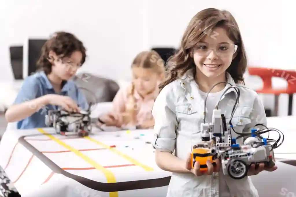 Mening qobiliyatimni ko'rsatgan, gulchi, baxtli, mutlaqo qiz maktabda to'g'ri turgan, robotni tutgan, hamkasblar loyiha ustida ishlayotganda. | Showing my talent smiling cheerful happy girl standing school holding robot while colleagues working project