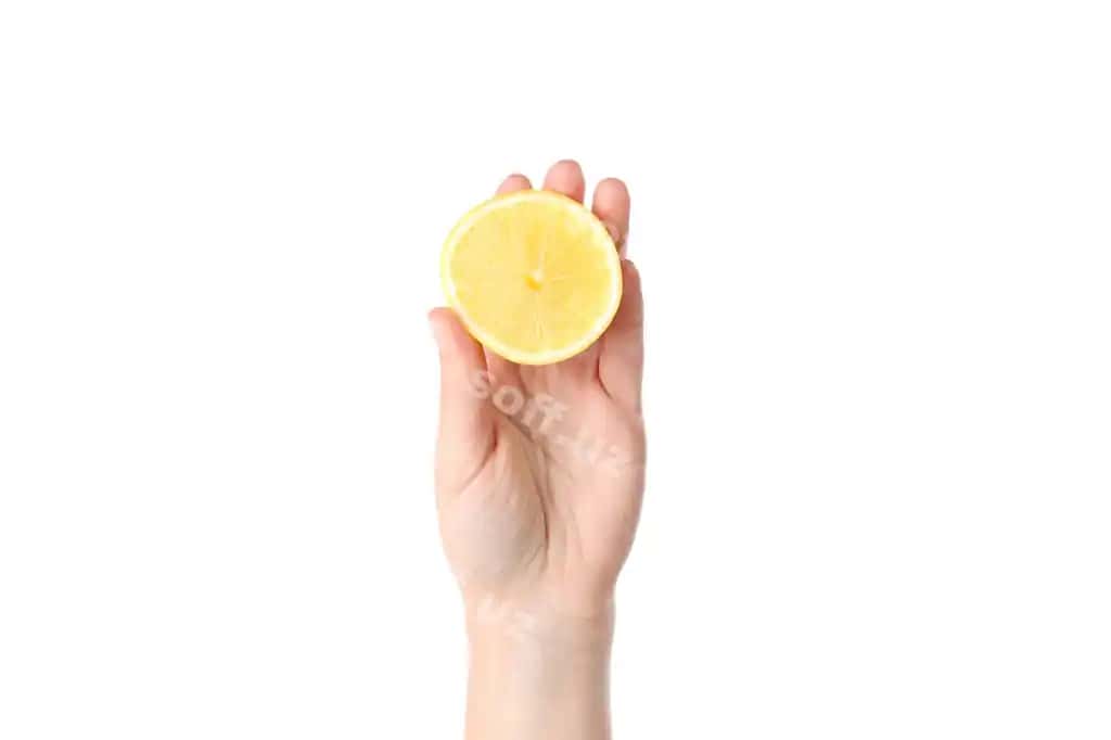 Ayol qo'l oq fonda ajraltirilgan yarımayni tutadi | Female hand holds half lemon isolated white background