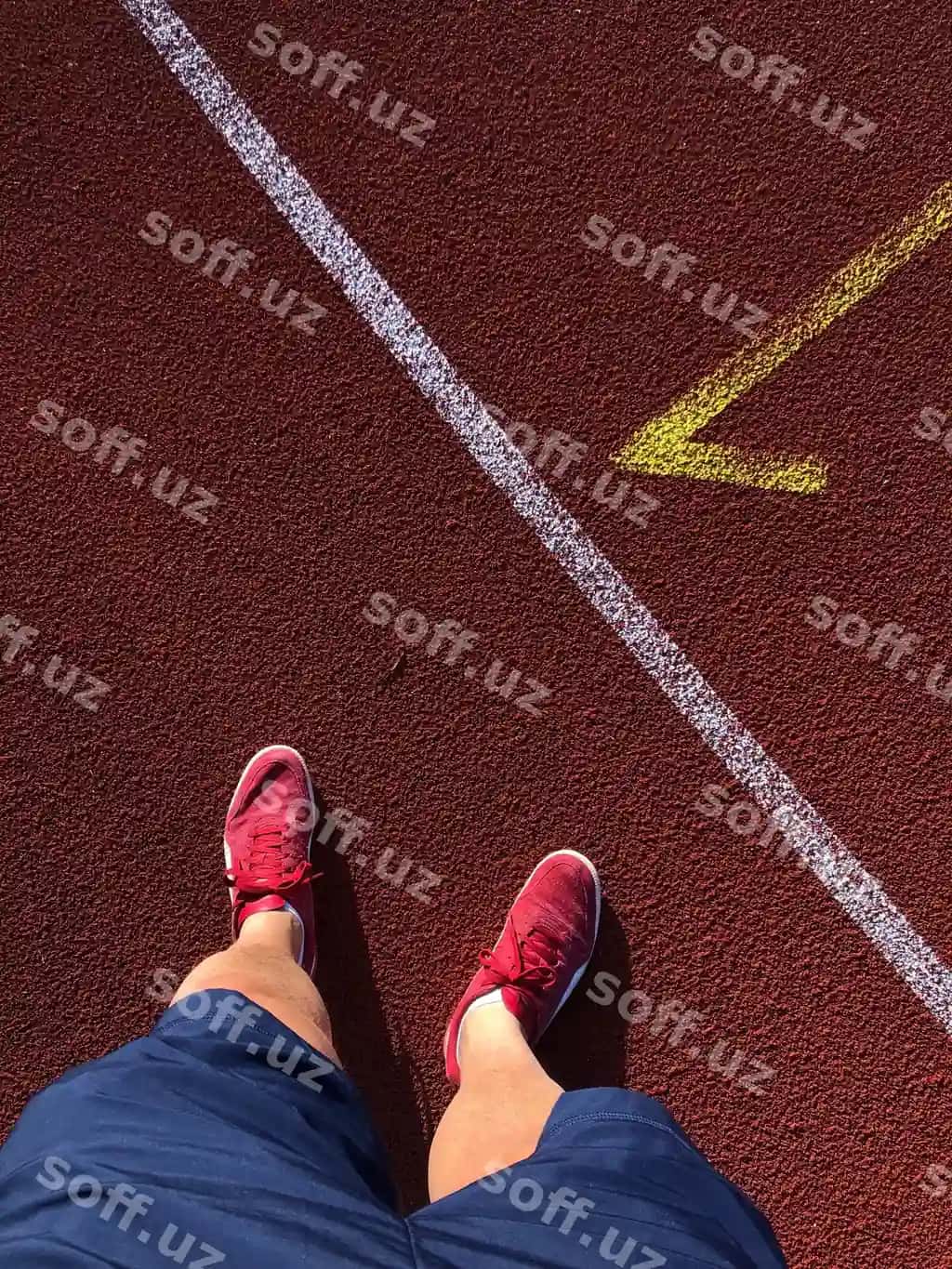Pastki qism erkak to'xtab turgan yug'ilish yo'li quyoshli kun | Low section man standing running track sunny day