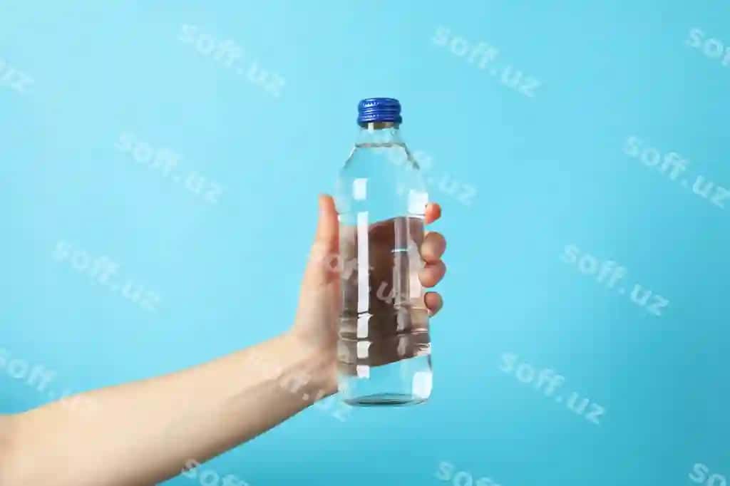 Ayol qo'lqi ko'k suwli shishani yaxshi ko'rinishda tutadi | Female hand holds bottle with water blue close up