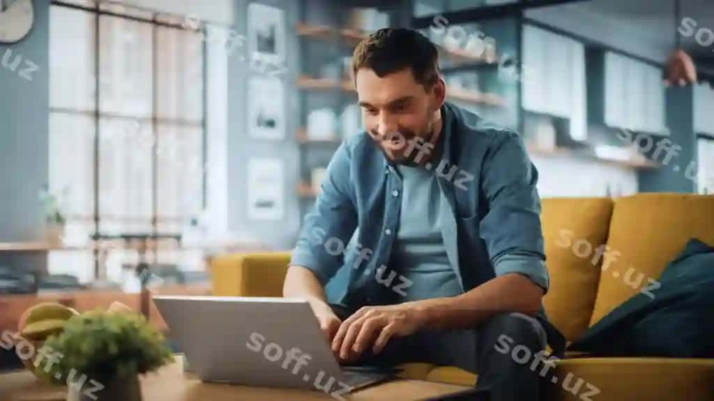 Er divanga choyxona stolga yonida laptop bilan o'tirgan. | Man sits couch coffee table with laptop