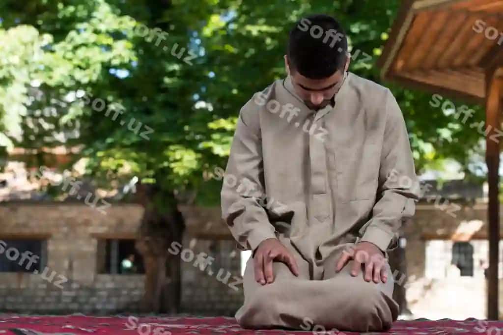 Yosh muslim erkak Allohga an'navoti namoz o'tiyotgan holda, an'navoti kallapoy kiygan. | Young muslim man making traditional prayer god while wearing traditional cap dishdasha