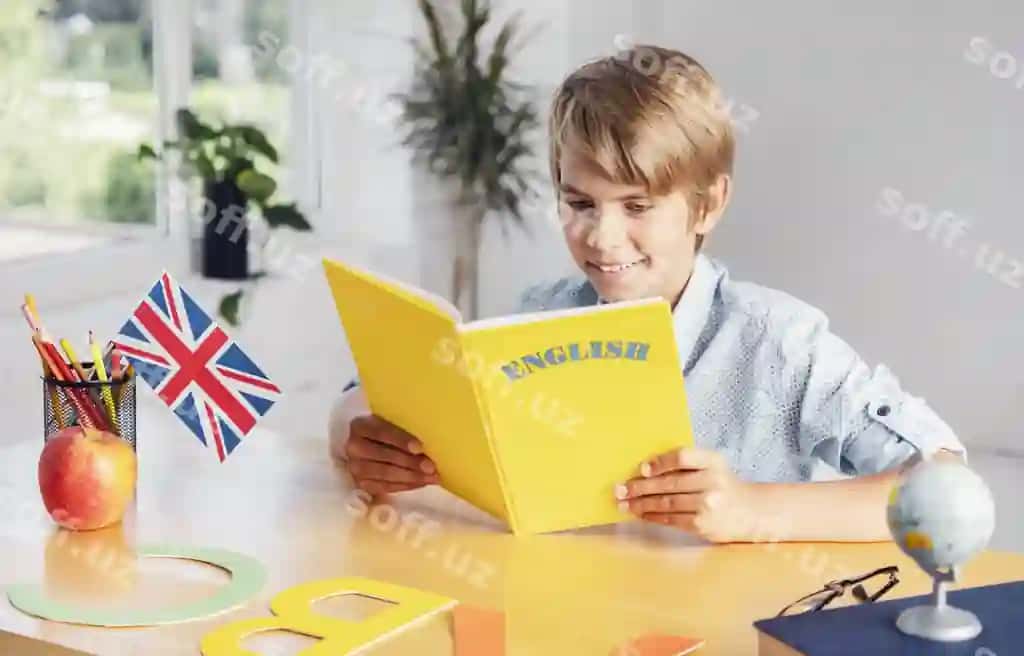 Baxtli gulchiq o'g'il yorqin sinf xonasida sariq ingliz tili kitobini o'qiyotgan. | Happy smiling boy reading yellow english language book light classroom