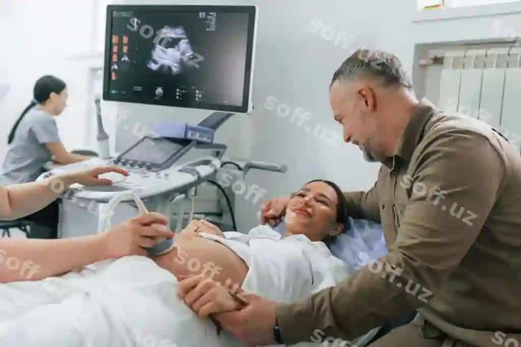 Er uning xotirasini qo'llab turibdi. Homilador ayol yotibdi. Shifokor uskunalash tekshiruvi amalga oshiradi. | Husband is supporting his wife pregnant woman is lying down hospital doctor does ultrasound