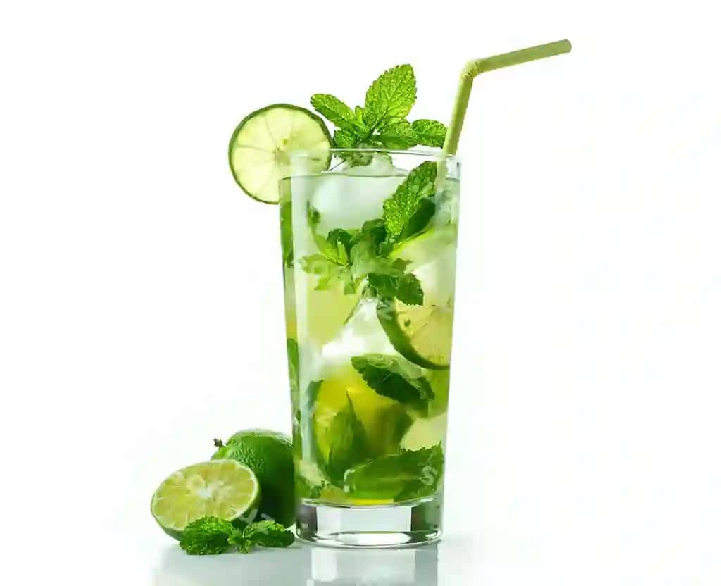 Yangi yalpiz barglari qo'shilgan uzun bo'yli shisha moxito, laym bo'laklari va muz kubiklari, somon jeneratori bilan bezatilgan | Tall glass mojito with fresh mint leaves lime slices ice cubes garnished with straw gener