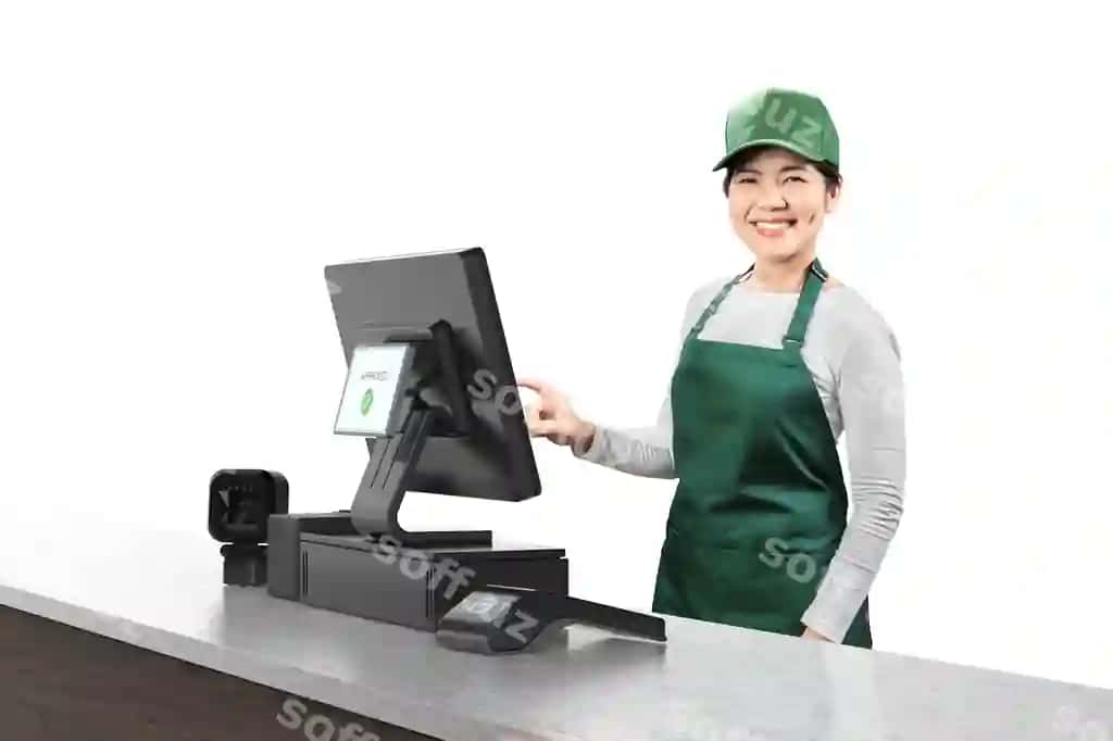 Faol sharqiy sotuvchi yashil kostyum kiyimoq, POS terminali bilan kassir stolida gulmoqda. | Active asian seller wear green uniform smiling with point sale terminal cashier desk