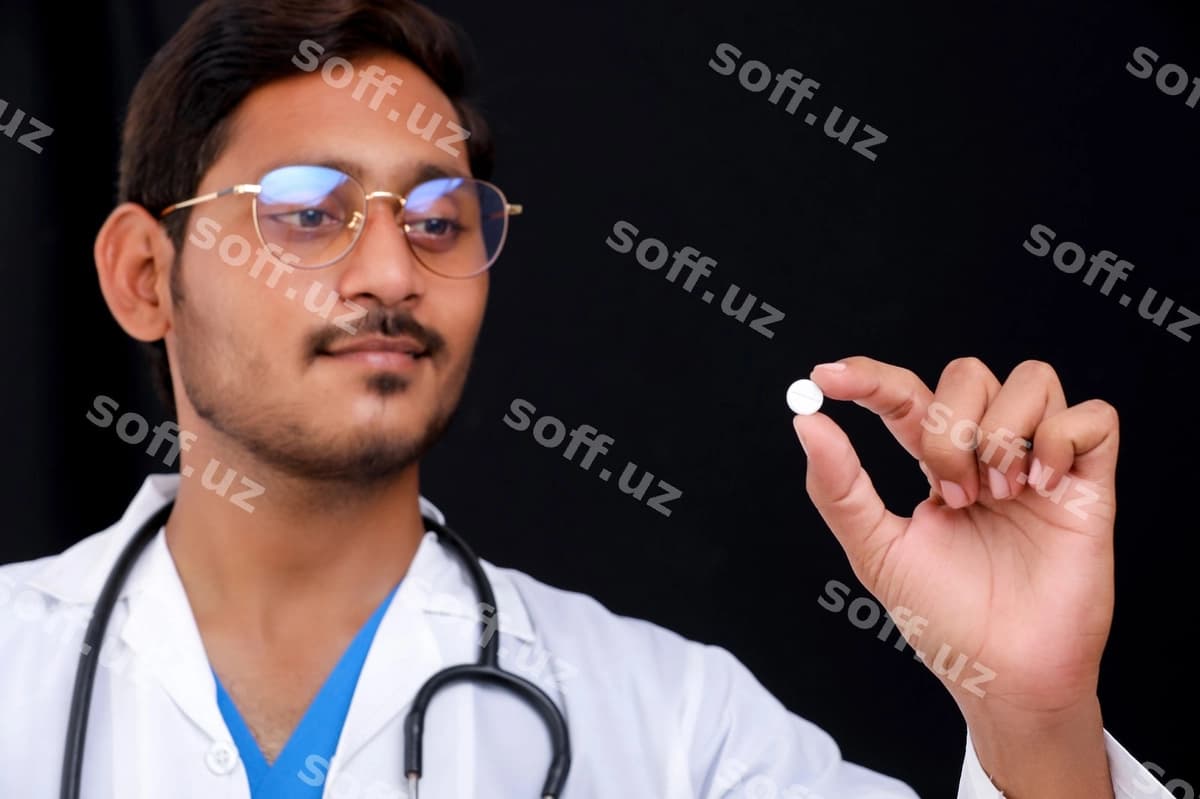 Yosh hindistonlik doktor qolqiqdagi tabletka ni tutgan | Young indian doctor holding pill hand