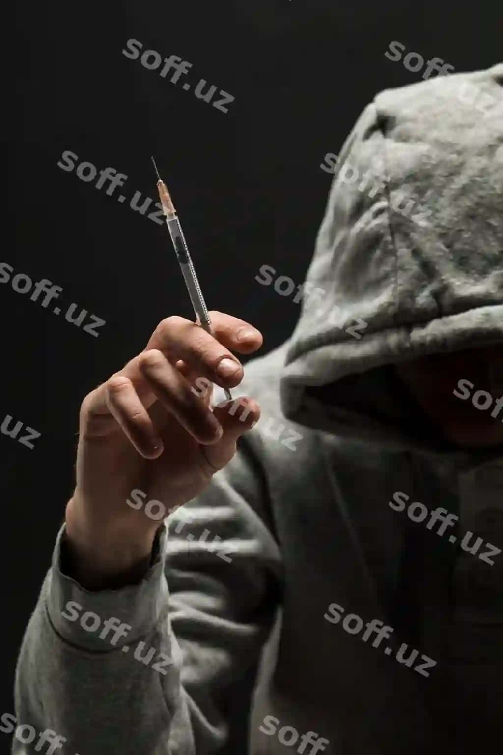 Bog'bon kulrang fudbolka bosh bog'lanishdan azob olaydi qorong'i qora fon. | Addict gray hoodie head suffers from addiction dark black background