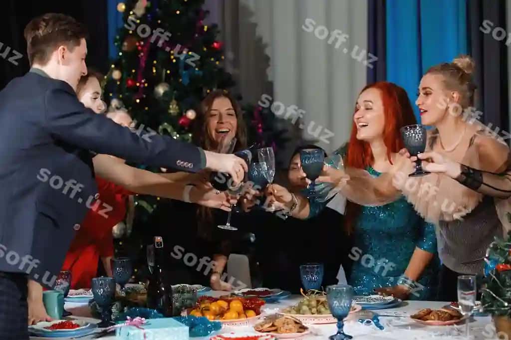 Bevosita do'stlar guruh Qrismas va Yangi yil bayramini nishonlarkan, er pufakchadan champaniya ko'zlarga qozotadi, ayollar guladi, stolga o'tirgan, Qrismas daraxti yonida. | Group happy friends celebrating christmas new year man pours champagne into glasses women laugh sitting table near christmas tree