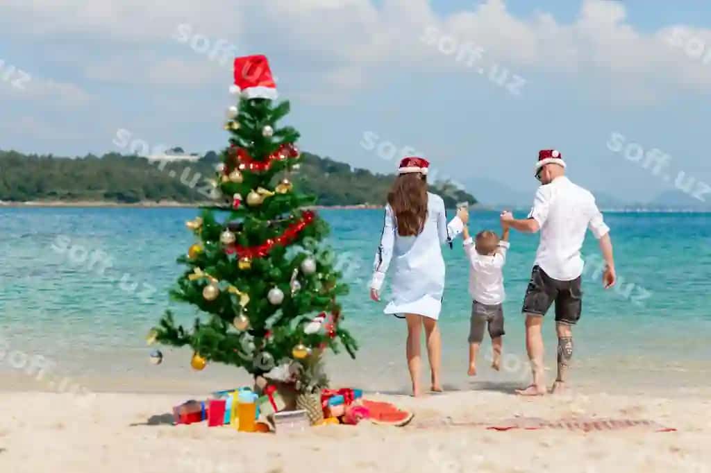 Yosh juftlik chiroyli bolasi bilan plyazhda Rojdestvo bayrami kontseptsiyasi | Young couple with cute son beach christmas celebration concept