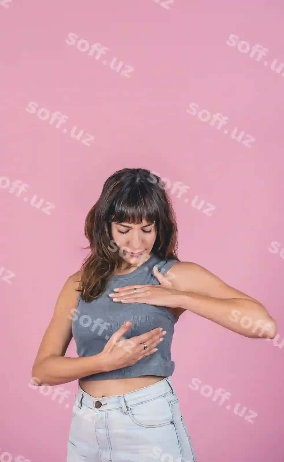 Ayol o'z-o'ziga mammari o'zgartishlarini tekshiradi pink fon matn joyi | Woman doing breast selfexam checking up breast changes pink background copy space
