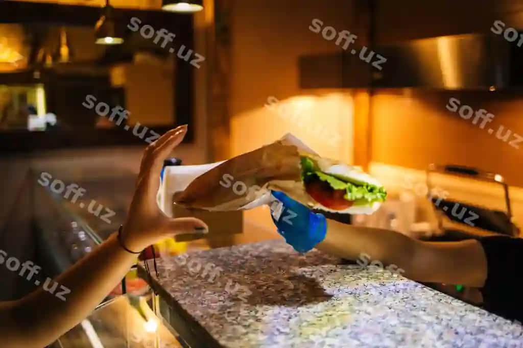 Kafe da mijozga letsegli engiliqli sendvichni ofitsiant olib o'tyotganini ko'r. | View waitress passing sandwich with lettuce customer cafe